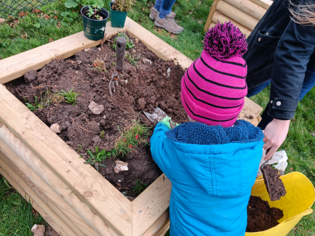 child digging in raised bed